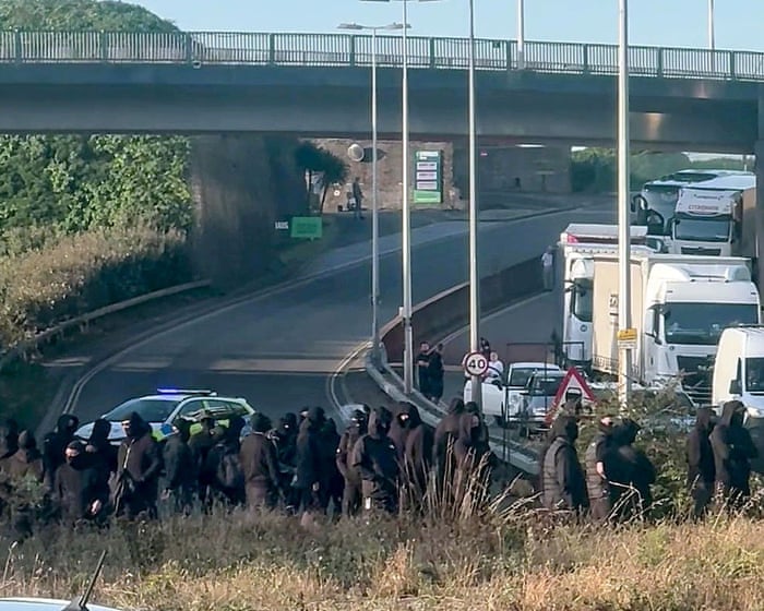 Protestujący ubrani na czarno i w kominiarkach zablokowali drogę w Porcie Dover w hrabstwie Kent.